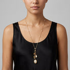Woman wearing a black top and an Elegant gold tone Faux Pearl Locket With Whistle Bell Charm Necklace