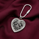 Silver tone Filigree Heart Carabiner Key Chain on a dark red fabric