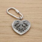 Silver tone Filigree Heart Carabiner Key Chain on a wooden surface