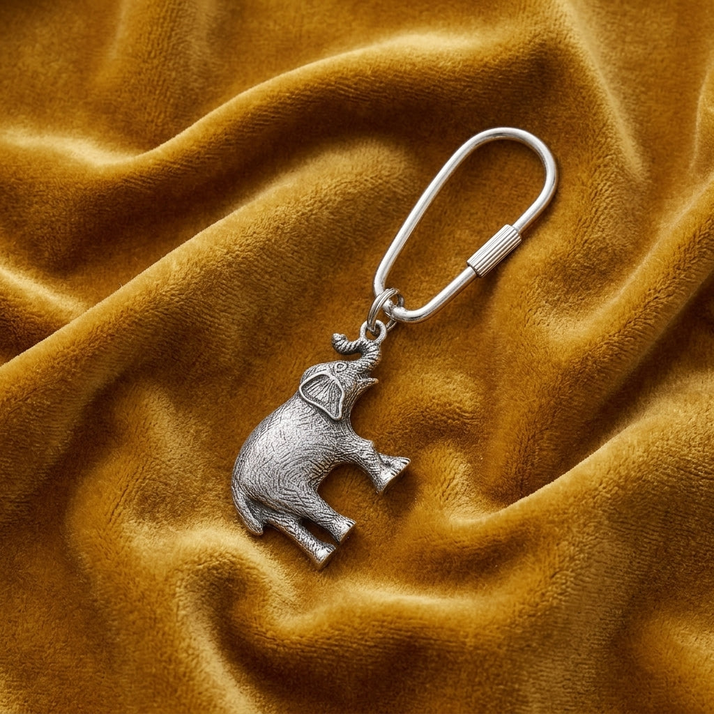 Pewter Elephant Key Ring on a textured brown fabric background