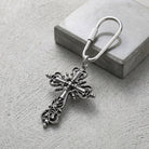 Classical silver tone Cross Carabiner Key Chain resting on a cement surface