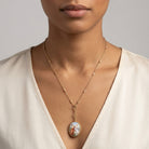 Woman in a white top wearing a gold tone Pre-Raphaelite Art Inspired Locket Necklace