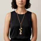 Woman wearing a gold tone Victorian Art Locket Plus Book & Heart Lockets Necklace