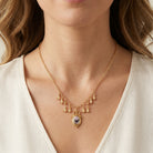 Woman in a white top wearing a Manor House Pink And Purple Rose Pendant Charms Necklace