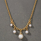 Gold tone Cinque White Faux Pearl Drop Necklace on cement surface