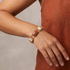 Person wearing a gold tone Oval Cameo & Goldstone Gemstone Link Bracelet
