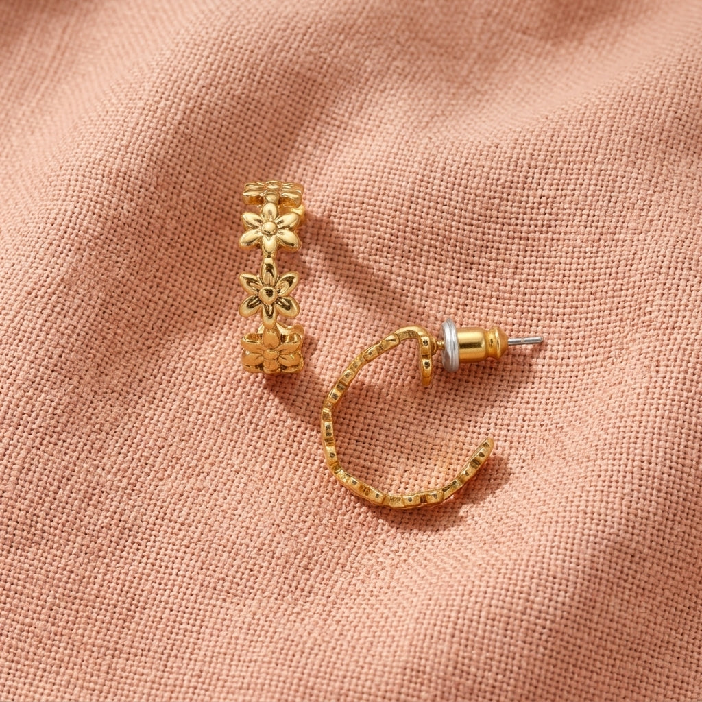 Gold Petite Summer Flower Hoop Earrings, displayed on a textured peach-pink fabric background.