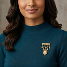 Woman wearing a teal sweater with a gold tone Dangling Charm Pink Cameo Bar Pin
