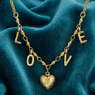 Gold tone Love Initials Heart Pendant Necklace on teal fabric 