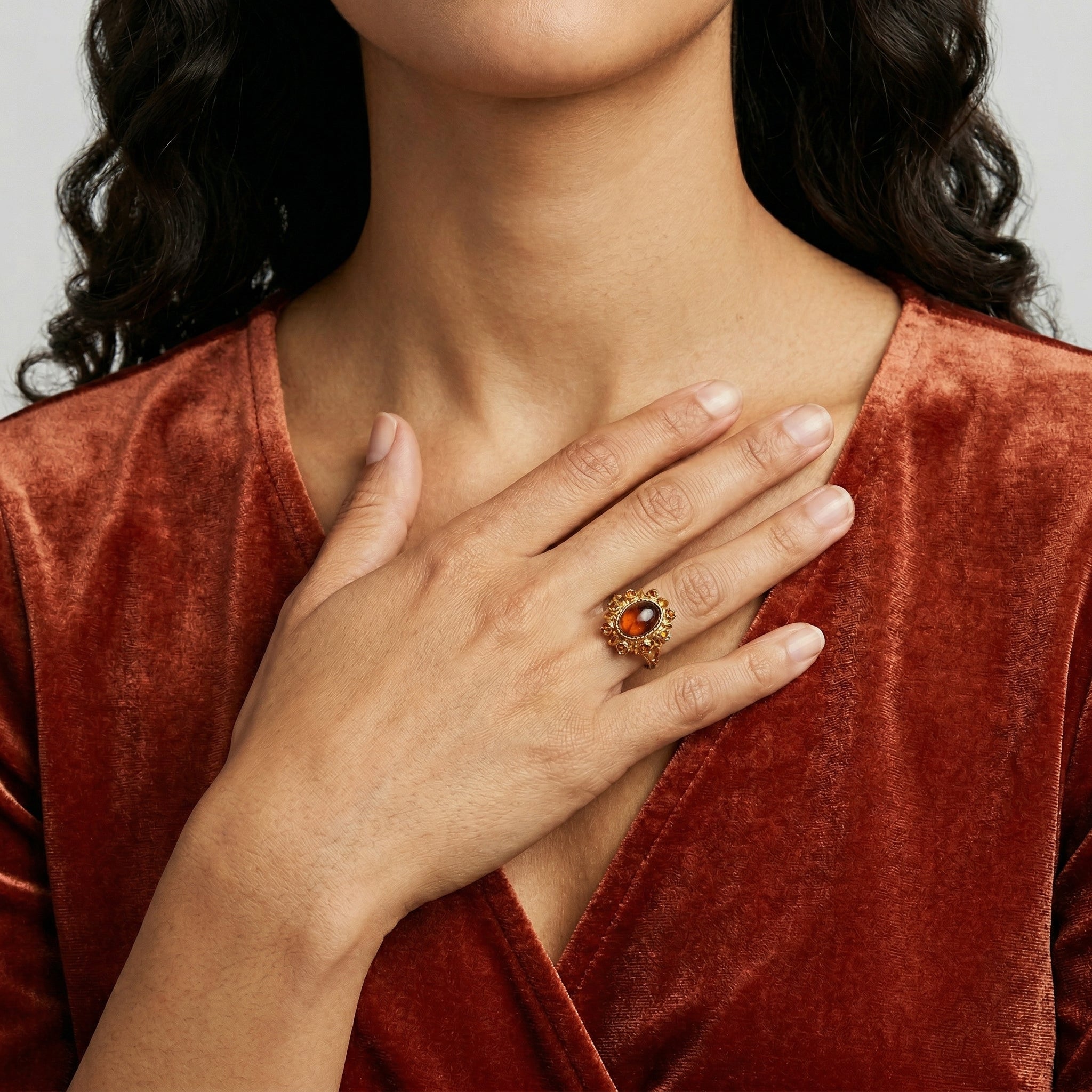 Woman wearing a red velvet top with a Sunburst Oval Smoke Topaz Glass Stone Crystal Ring
