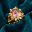 Gold tone Sunburst Oval Light Pink Austrian Crystal Ring on a teal fabric background