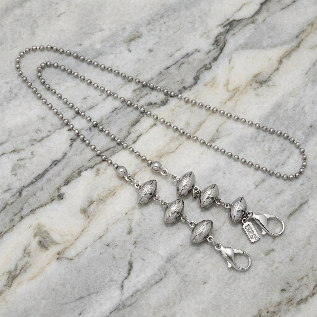 Stainless Steel Football Face Mask Chain on a marble surface