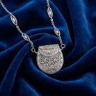 Vintage Purse Pendant Necklace on a blue fabric background