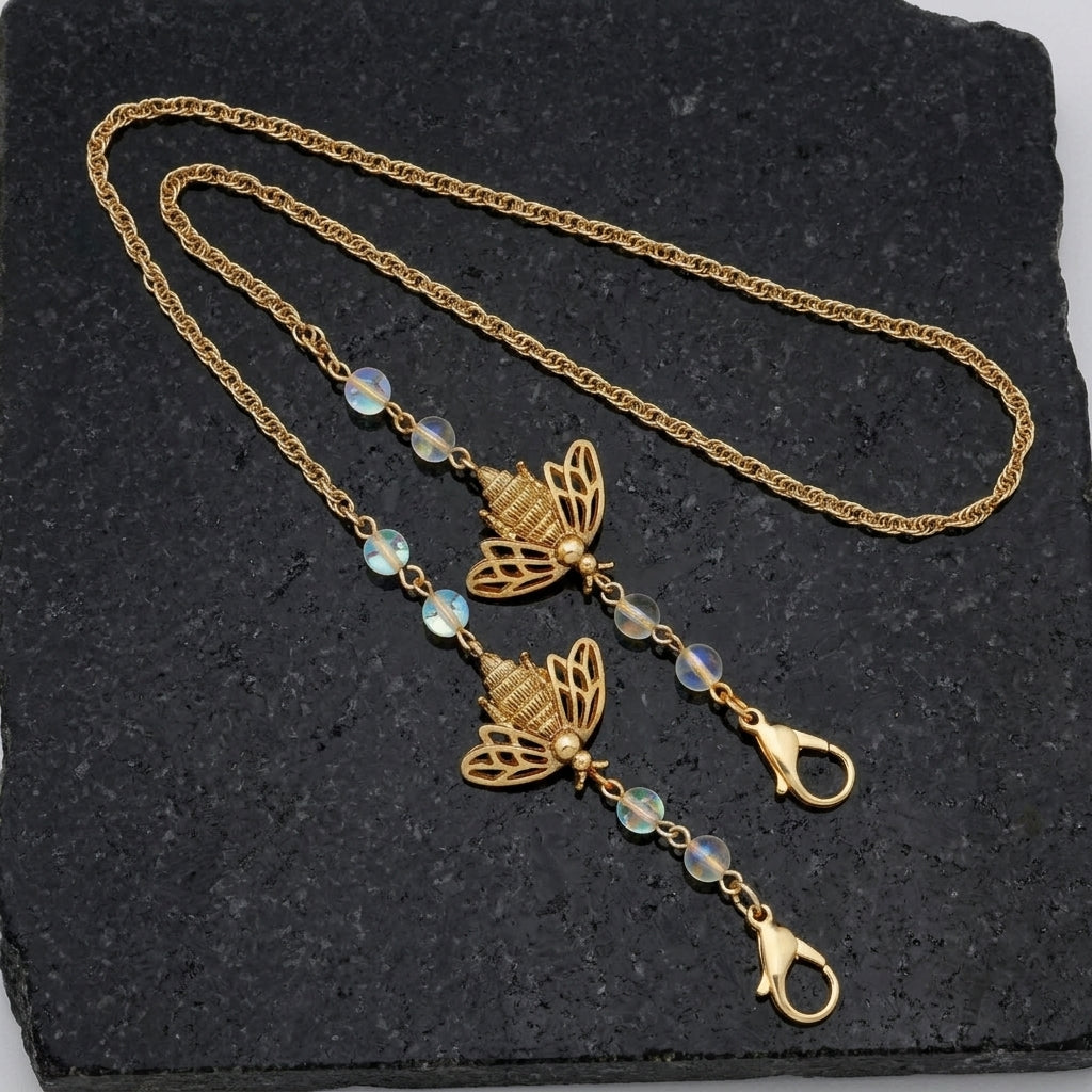 Bee Face Mask Chain Holder With AB Crystals resting on dark stone
