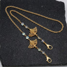 Bee Face Mask Chain Holder With AB Crystals resting on dark stone