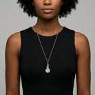 Woman wearing a black sleeveless top with a Sitting Cat On Round Turquoise Gemstone Pendant Necklace