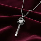 Antiqued Heart Whistle Pendant Necklace on a maroon fabric background
