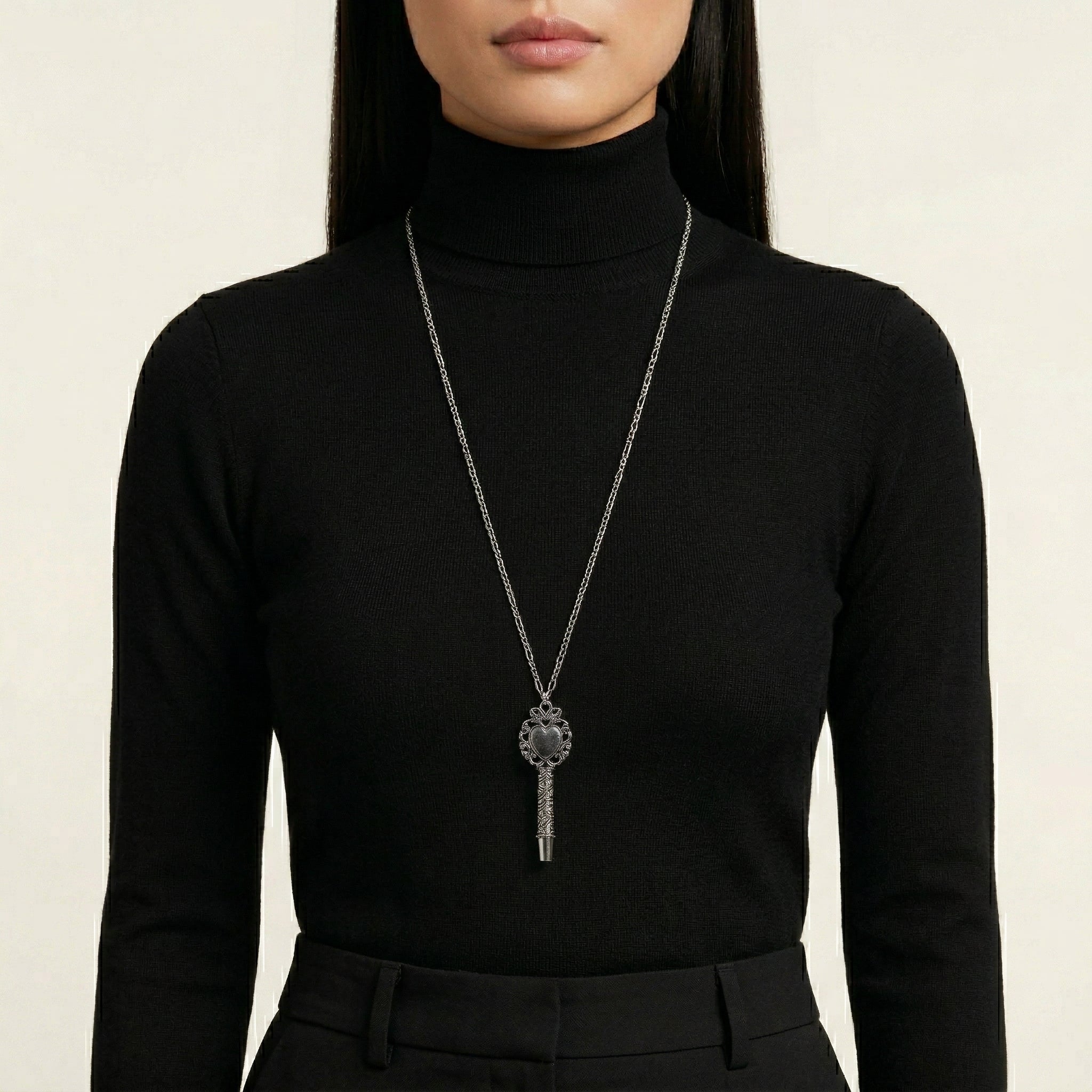 Person wearing a black turtleneck and a long Antiqued Heart Whistle Pendant Necklace