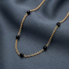 Jet Black Faceted Glass Beaded Necklace resting on gray smooth fabric