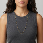 Woman in a dark sleeveless top with dark hair wearing a Minuit Black Glass Beaded Link Necklace