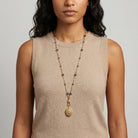Woman wearing a long Blue Montana Glass Beaded Double Side Oval Floral Locket Necklace