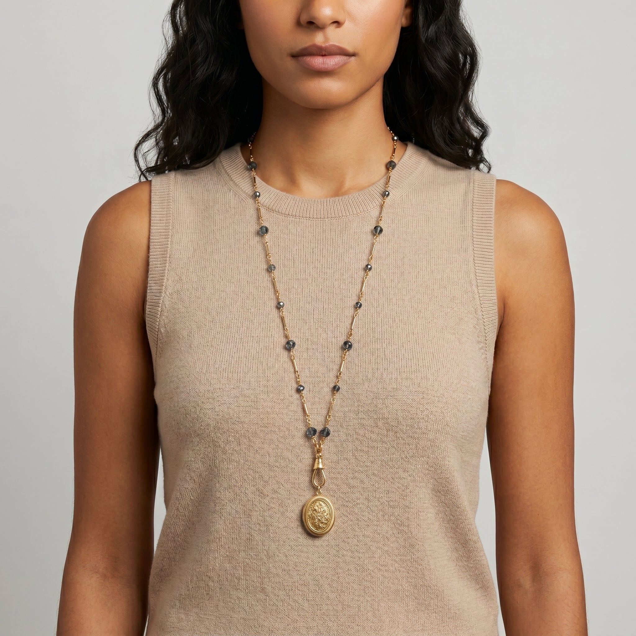 Woman wearing a long Blue Montana Glass Beaded Double Side Oval Floral Locket Necklace