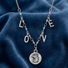 Petite Horse Head Pendant LOVE Initials Necklace on a blue fabric background