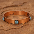 Round Turquoise Stone Bangle Bracelet on a sandy background