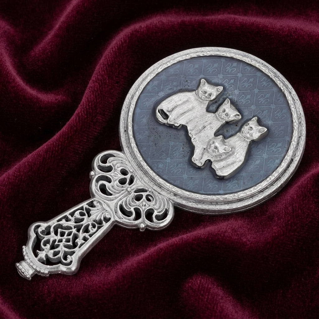 Blue Enamel Four Cats Handheld Round Mirror on a dark red fabric background