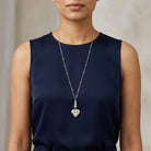 Woman wearing a navy blue top with a silver Sitting Cat And Heart Locket Necklace