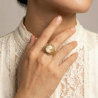 Close-up of a hand wearing a gold tone Twin Muse And Bird Cameo Ring