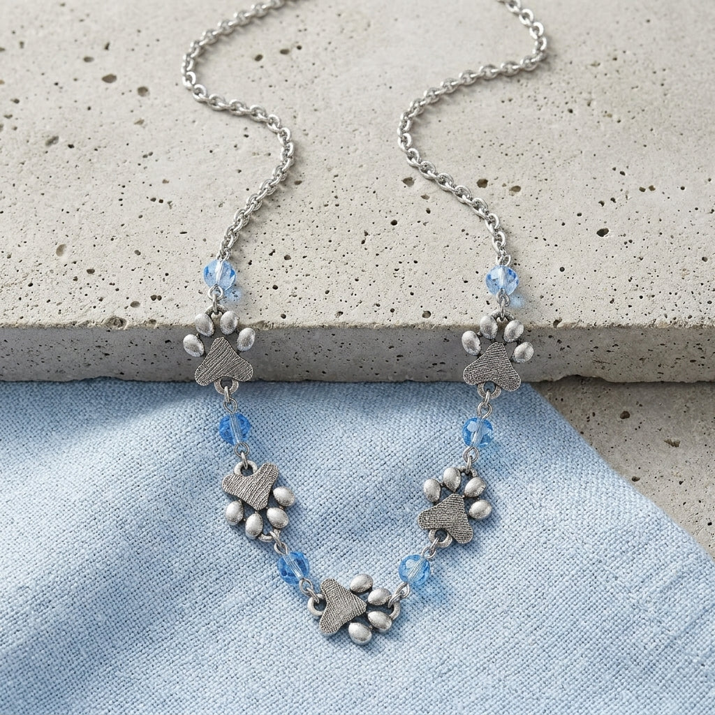 Light Blue Sapphire Bead Pewter Paw Necklace on a light blue fabric background
