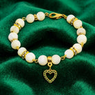 Mother of Pearl Crystal Birthstone Heart Charm Bracelet on green fabric