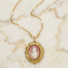 Victorian Reflections Carnelian & Ivory Cameo Pendant Faux Pearl Necklace on a marble background