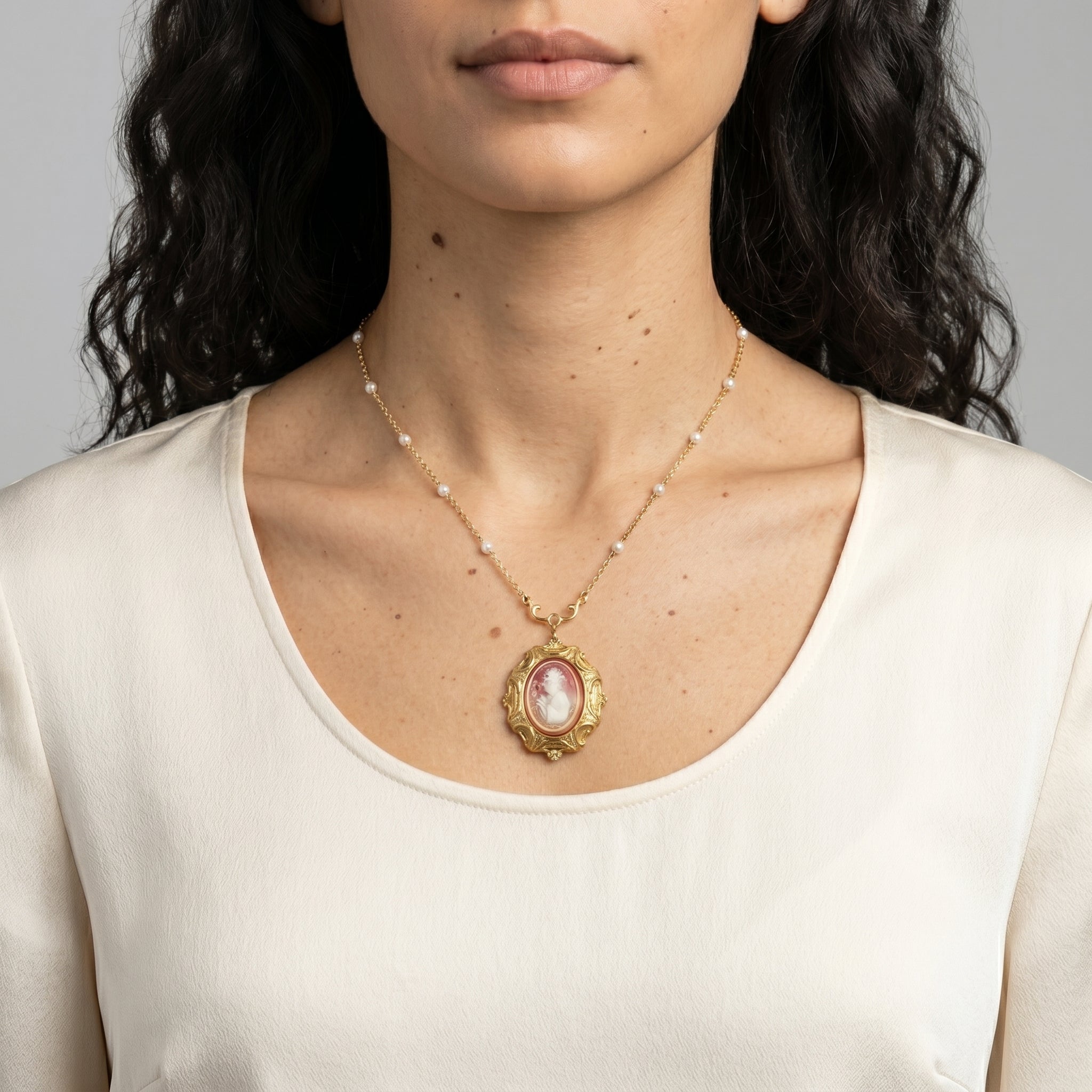 Woman wearing a Victorian Reflections Carnelian & Ivory Cameo Pendant Faux Pearl Necklace