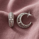 Silver Ornate Filigree Hoop Earrings displayed on a textured dusty rose fabric background.