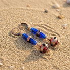 Bohemian Sapphire Blue & Brown Bead Dangle Earrings on a sandy surface