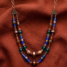 Bohemian Multi Color Double Stranded Necklace on a dark red and orange fabric