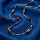 Bohemian Multi Color Strandage Necklace on a blue fabric background