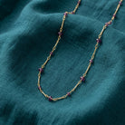 Purple Beaded Chain Necklace on a teal fabric background