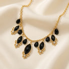 Black Teardrop Crystal Necklace on a beige fabric background