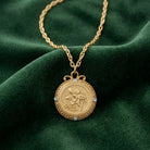 Flower of The Month Crystal Pendant Necklace with clear crystal accents on green fabric