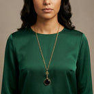 Deco Black Faceted Stone Pendant Necklace worn by a woman with a green top 