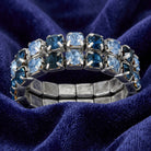 Blue crystal ring resting on a dark blue fabric 