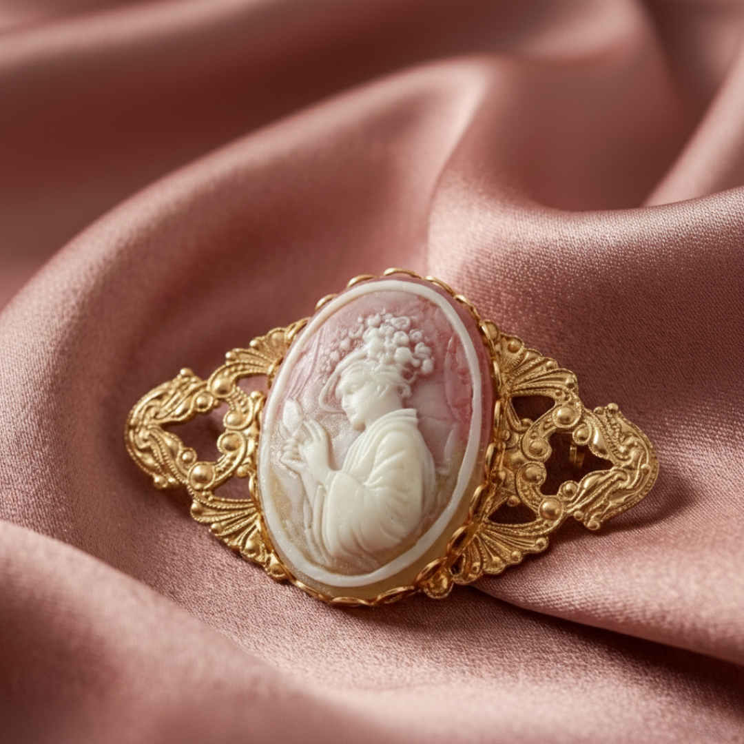 Vintage-style gold cameo brooch on pink fabric