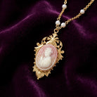Victorian Reflections Carnelian & Ivory Cameo Faux Pearl Accent Necklace on dark purple fabric