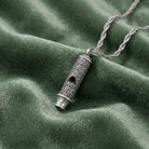 Lesser Celandine Flower Whistle Pendant Necklace on green fabric