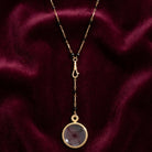 Black Bead Magnifying Glass Drop Necklace on dark maroon fabric