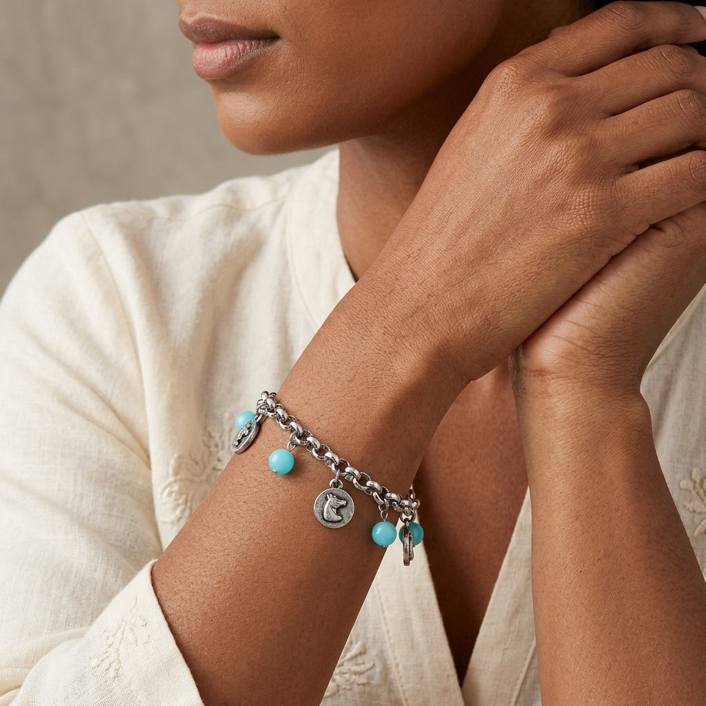 Southwest Turquoise Bead Horse Head Charm Link Bracelet worn by a woman in a cream top 