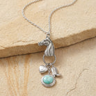 Southwest Horse Head Turquoise Locket & Charms Necklace on beige stone surface